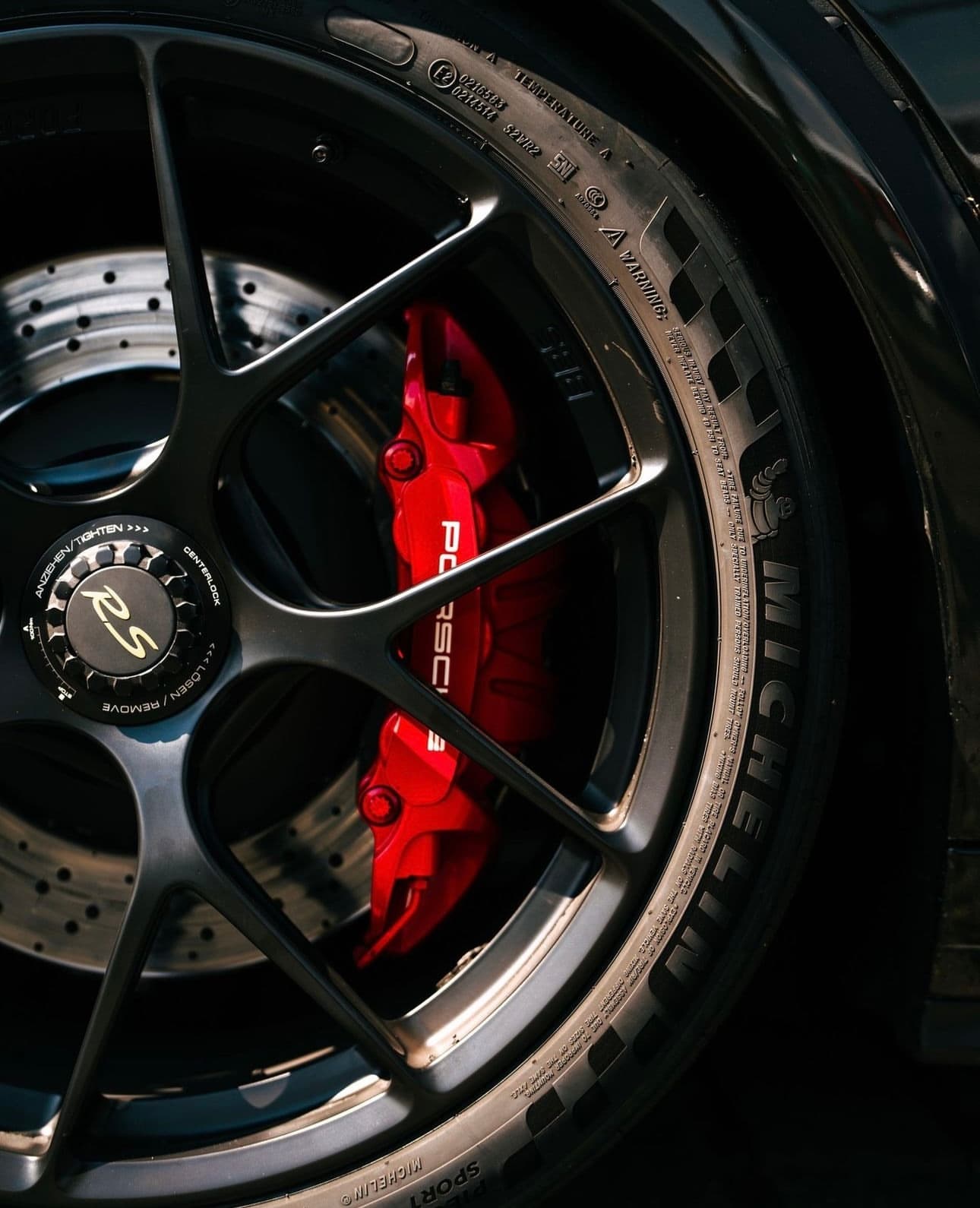 Nahaufnahme eines Porsche RS Rads auf Michelin Reifen mit rotem Bremssattel